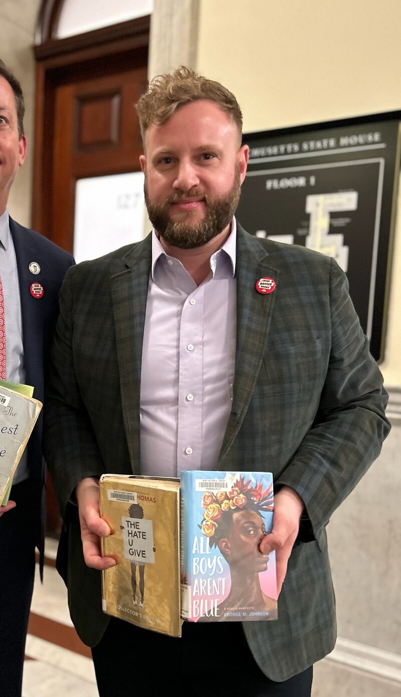 State Senator Julian Cyr at the Massachusetts State House holding the book All Boys Aren't Blue